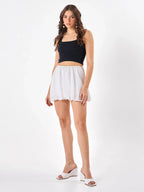 Female model wearing a white mini skirt  from Stylera