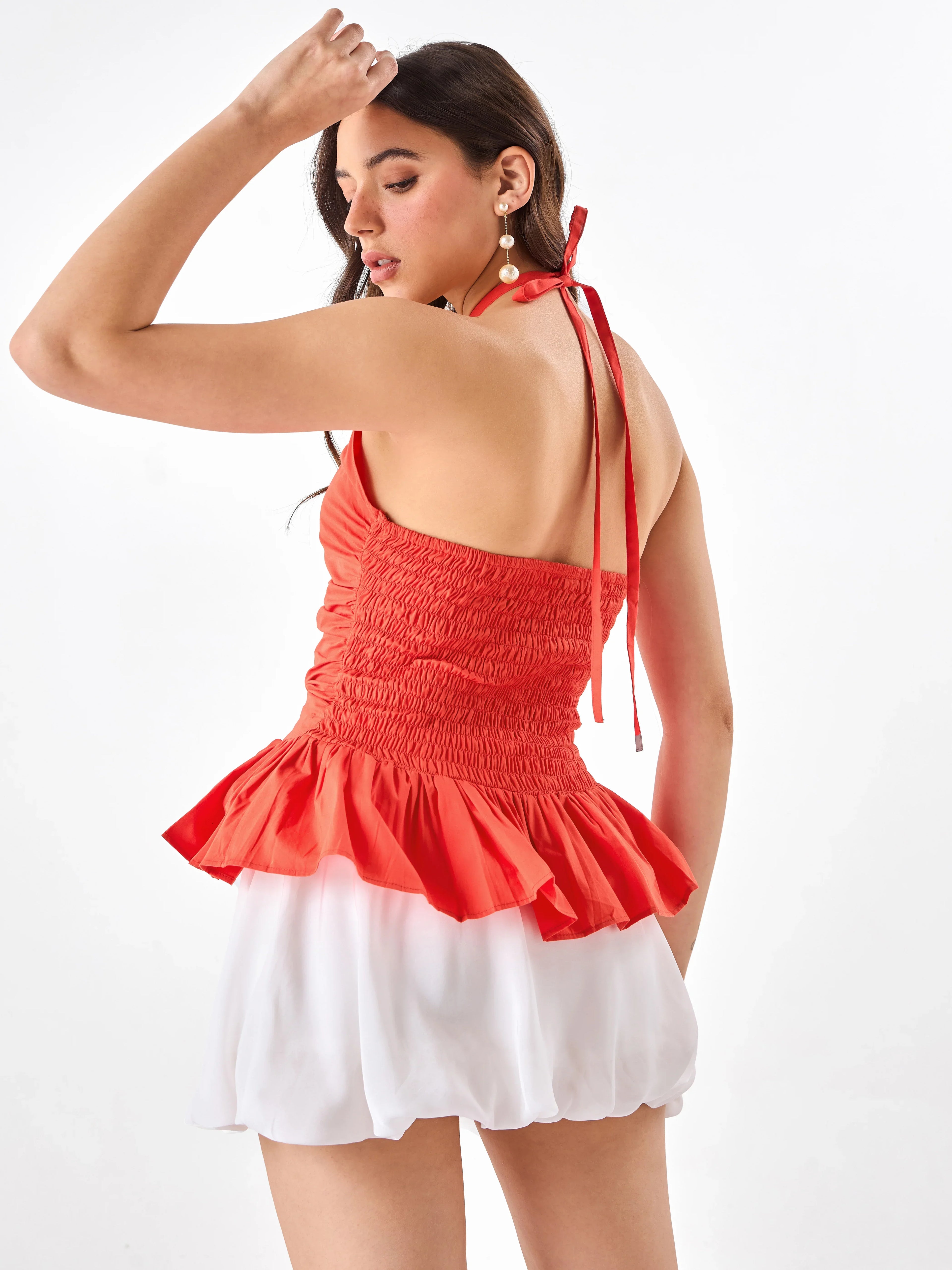 Female model wearing a orange halter top from Stylera, showcasing backside