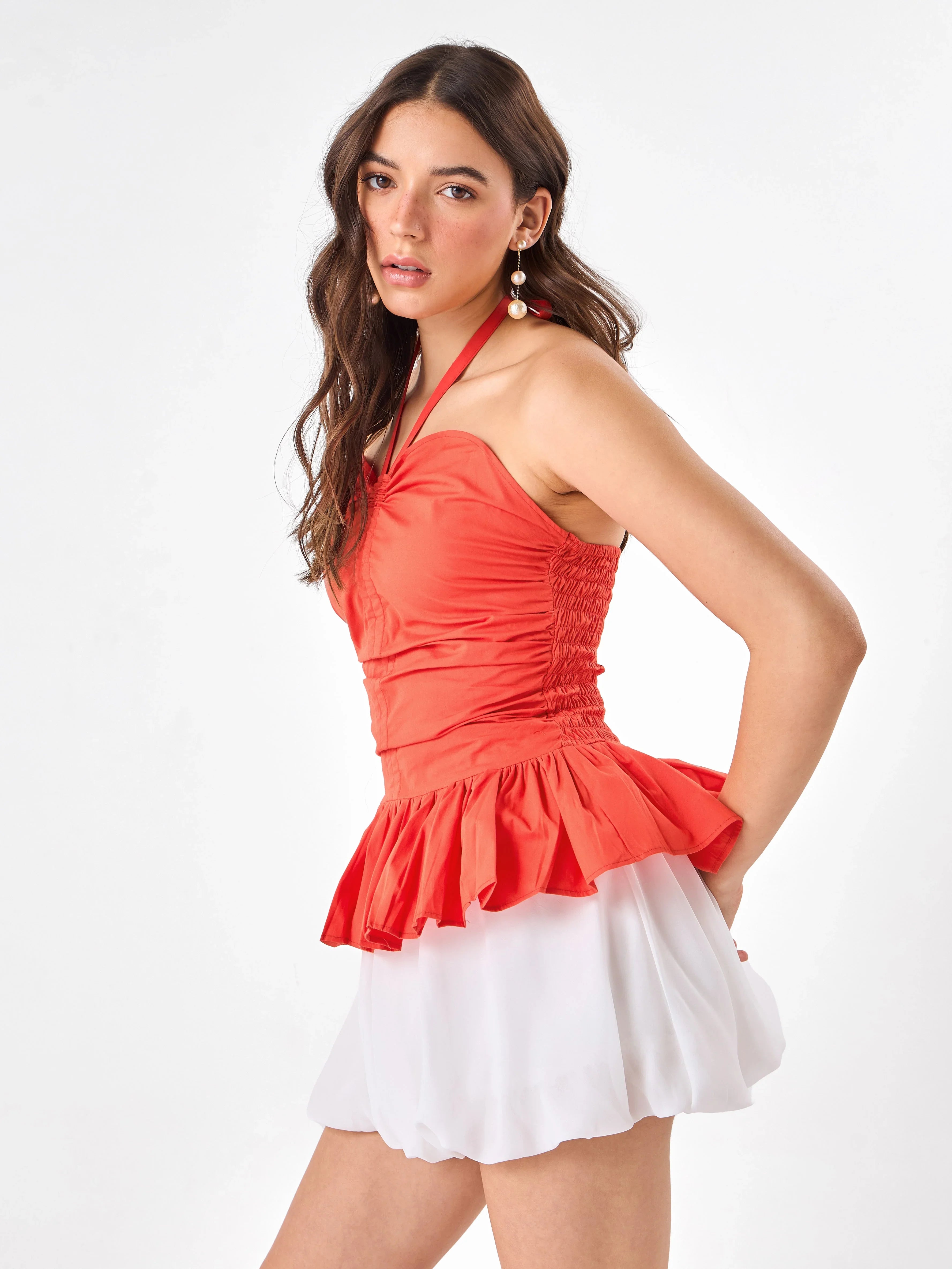 Female model wearing a orange halter top from Stylera, showcasing side angle