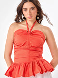 Female model wearing a orange halter top from Stylera
