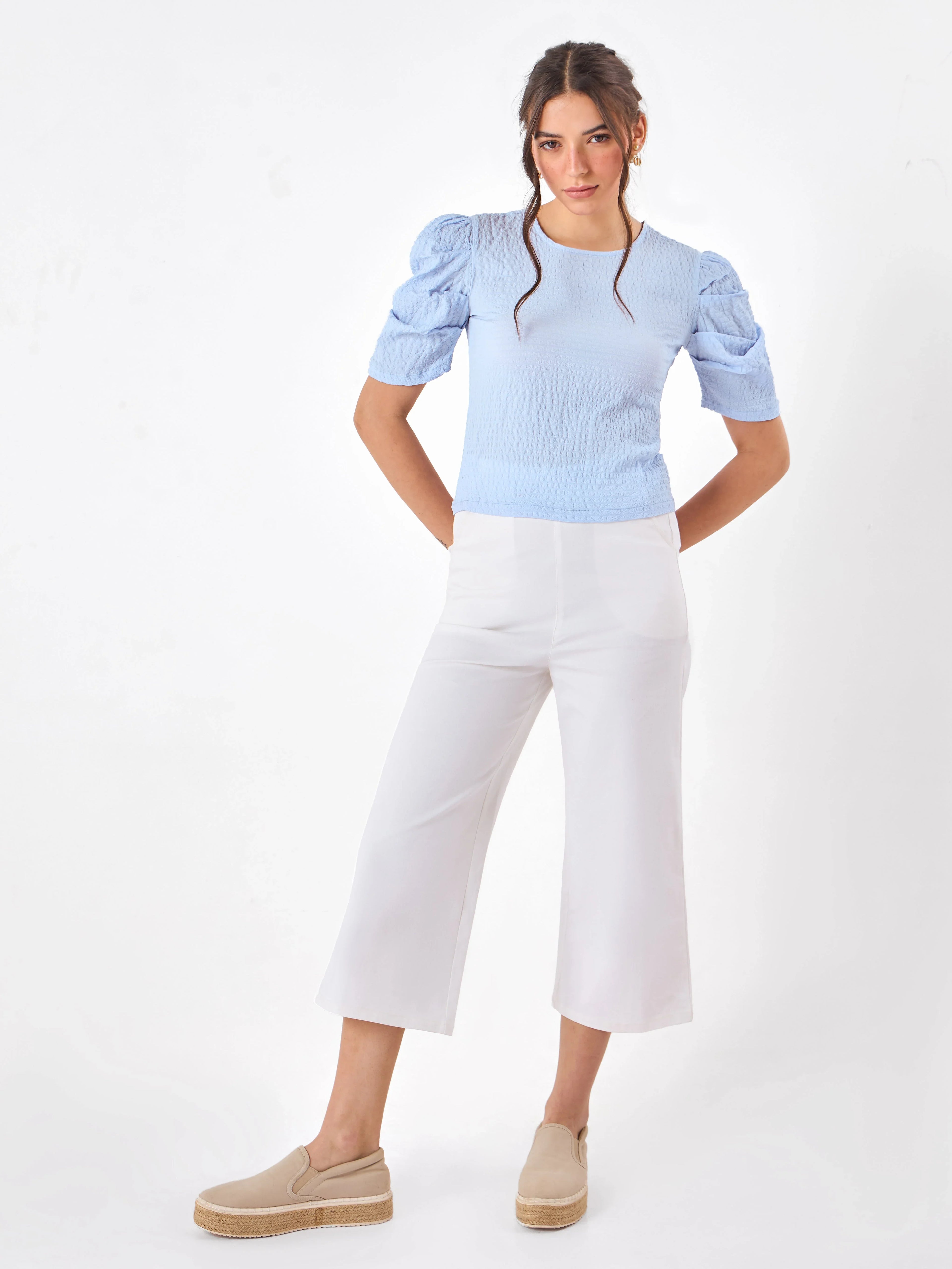 Female model wearing a light blue top from Stylera
