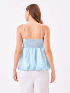 Female model wearing a light blue floral top from Stylera, showcasing backside