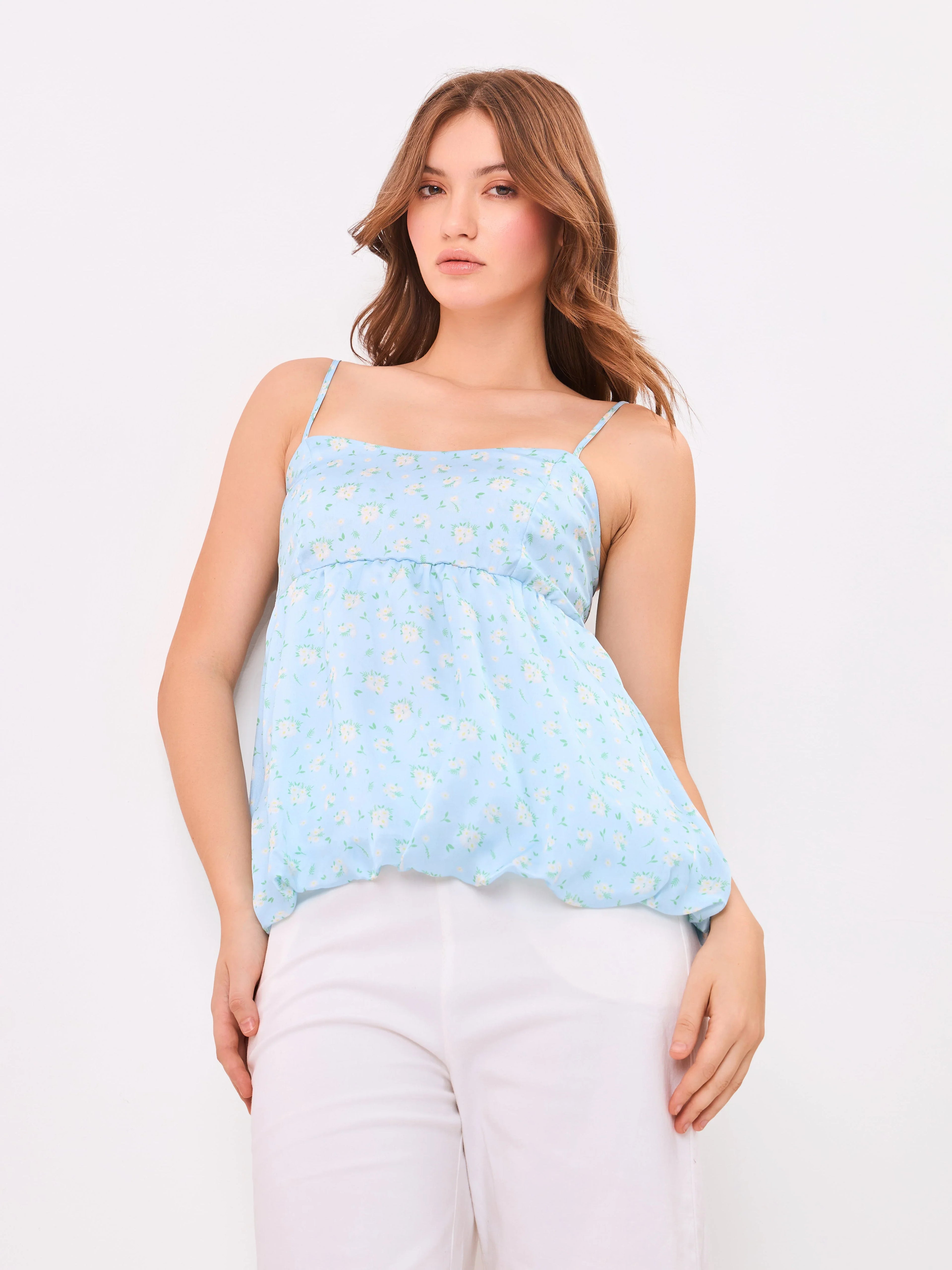 Female model wearing a light blue floral top from Stylera
