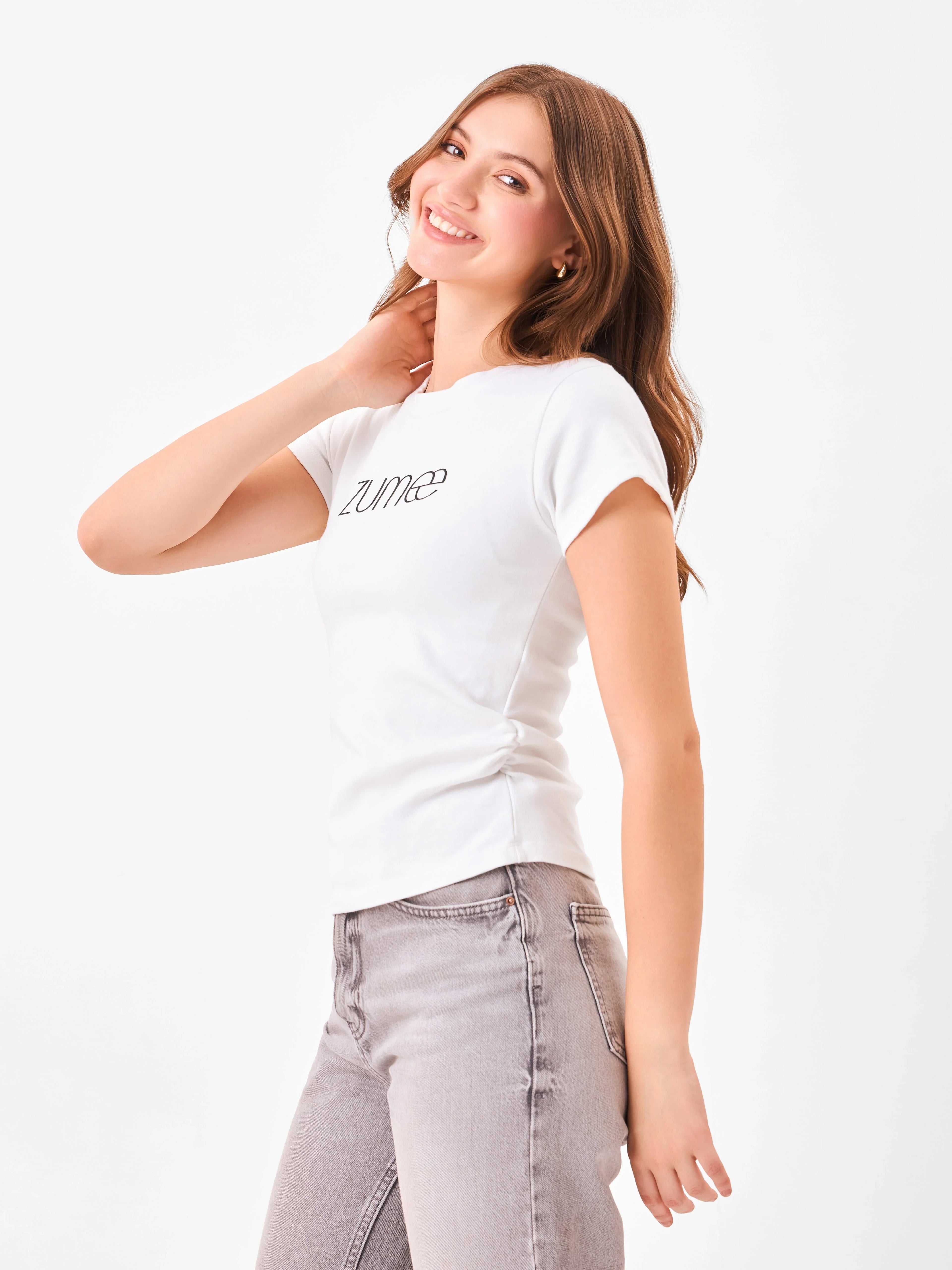 Female model wearing a white shortsleeve t-shirt with 'Zume' logo from Stylera