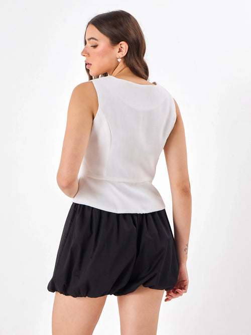Female model wearing a white sleeveless top from Stylera, showcasing backside