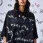 Model wearing Stylera black scribble print shirt oversized button front with white doodle graphics