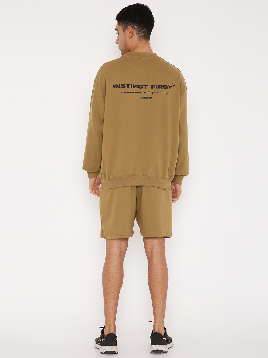 Back view of man wearing Stylera brown graphic sweatshirt for men with black back logo and relaxed fit