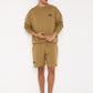 Stylera brown graphic sweatshirt for men modeled with matching shorts and black sneakers