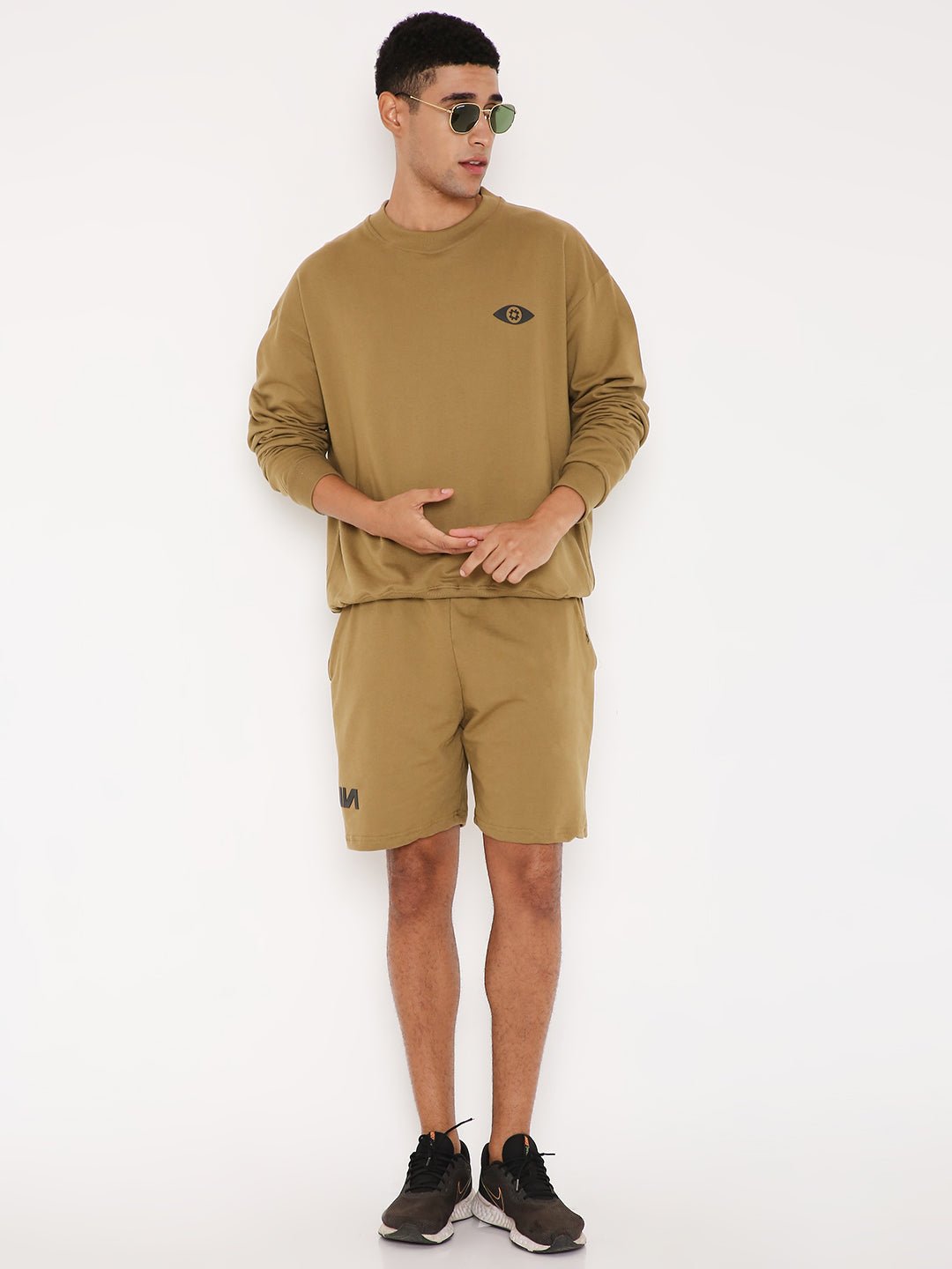 Stylera brown graphic sweatshirt for men modeled with matching shorts and black sneakers