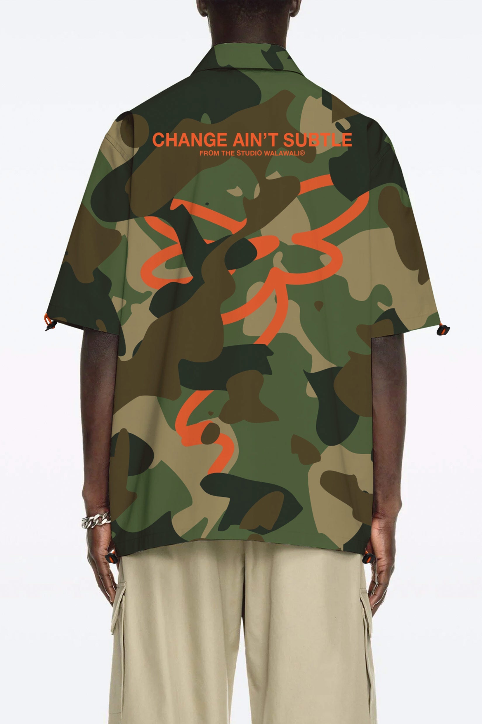 Stylera camo bowling shirt back view showing green camouflage with orange graphic text and abstract logo
