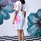 Back view of model in white lace up back casual floral dress for women with puff sleeves and platform sneakers