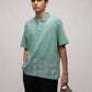 Stylera mint green short sleeve polo on male model holding gray cap casual men's fashion polo