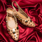 Light Gold studded flats heels by Stylera with decorative round studs on satin background