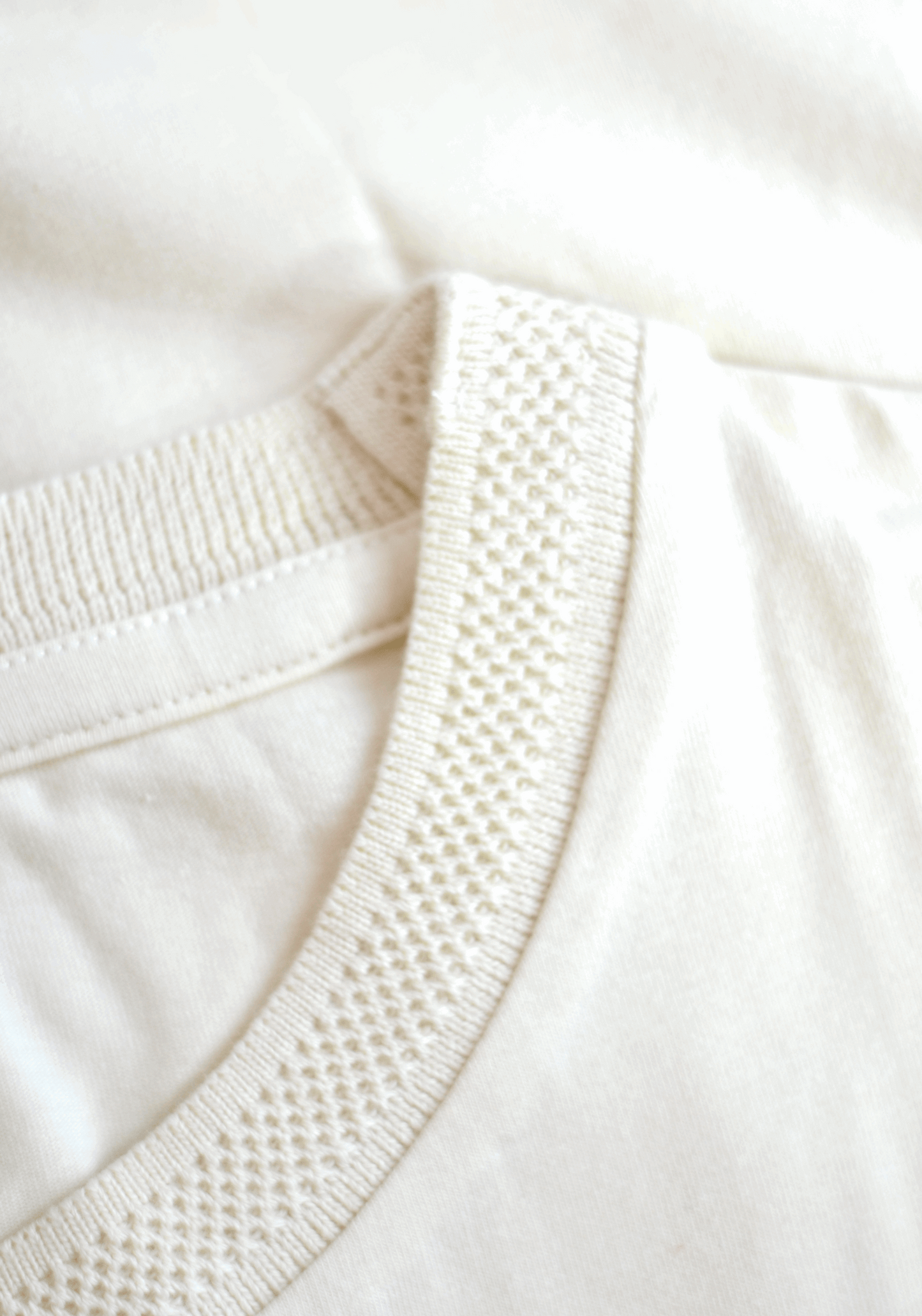 Close-up of Stylera men's trendy cream t-shirt collar with textured ribbed detail