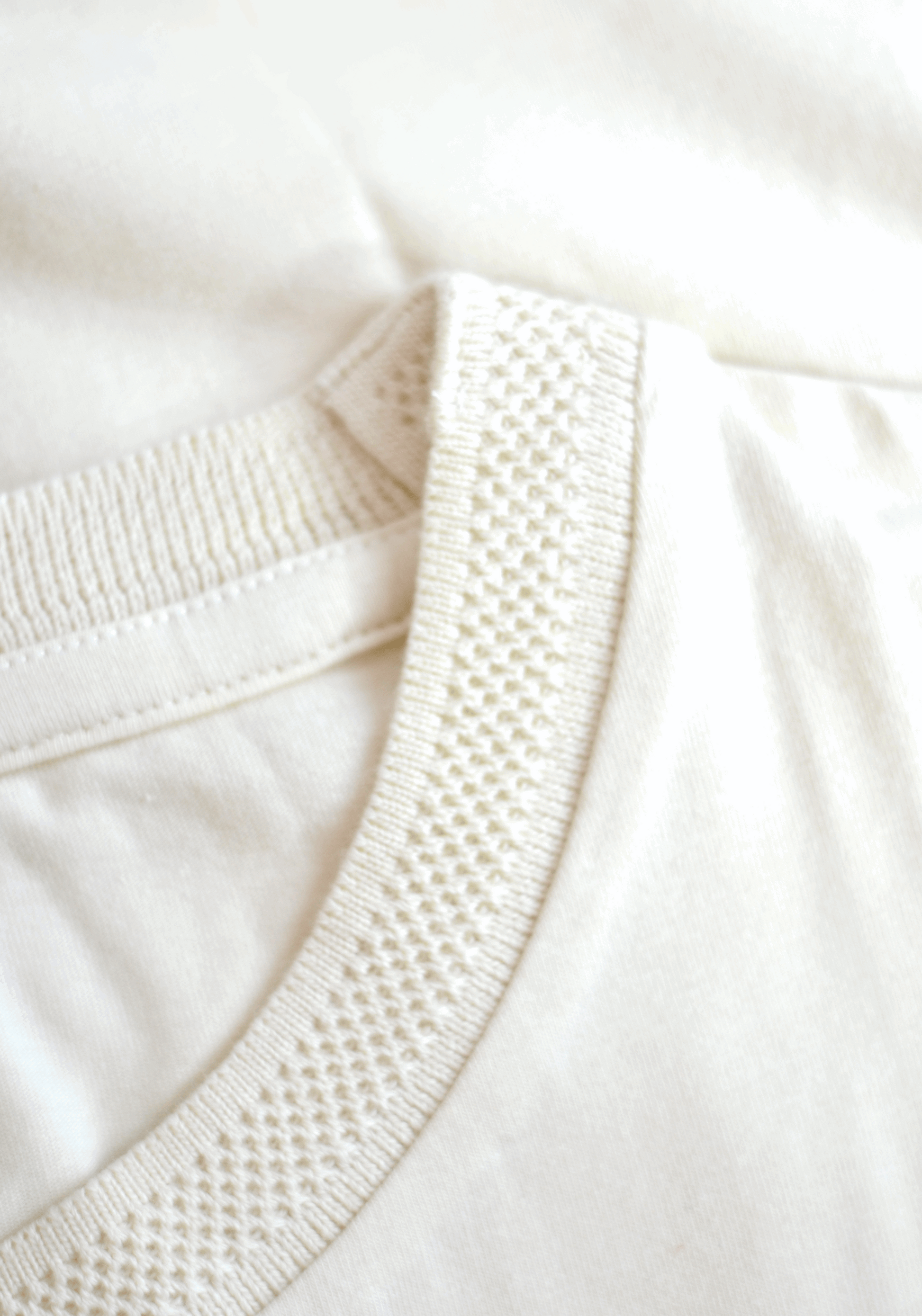 Close-up of Stylera men's trendy cream t-shirt collar with textured ribbed detail