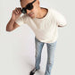 Man wearing Stylera men's trendy cream t-shirt paired with light blue jeans and black sneakers