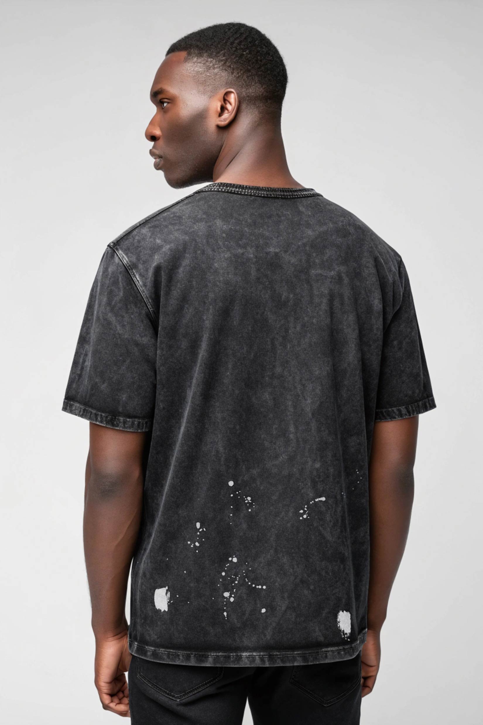 Stylera men's trendy graphic tee washed black back view with paint splatter distress on model
