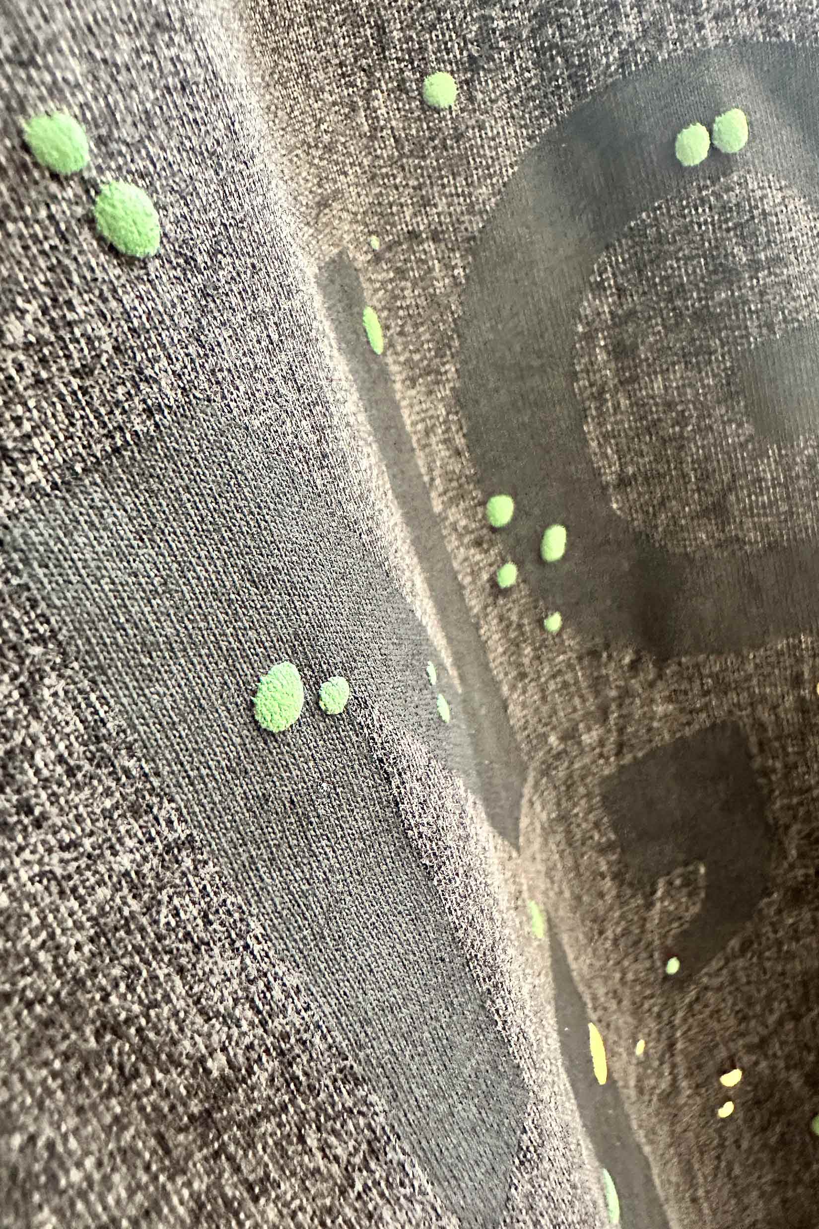 Stylera men's trendy graphic tee charcoal closeup with faded black lettering and neon green paint splatter dots
