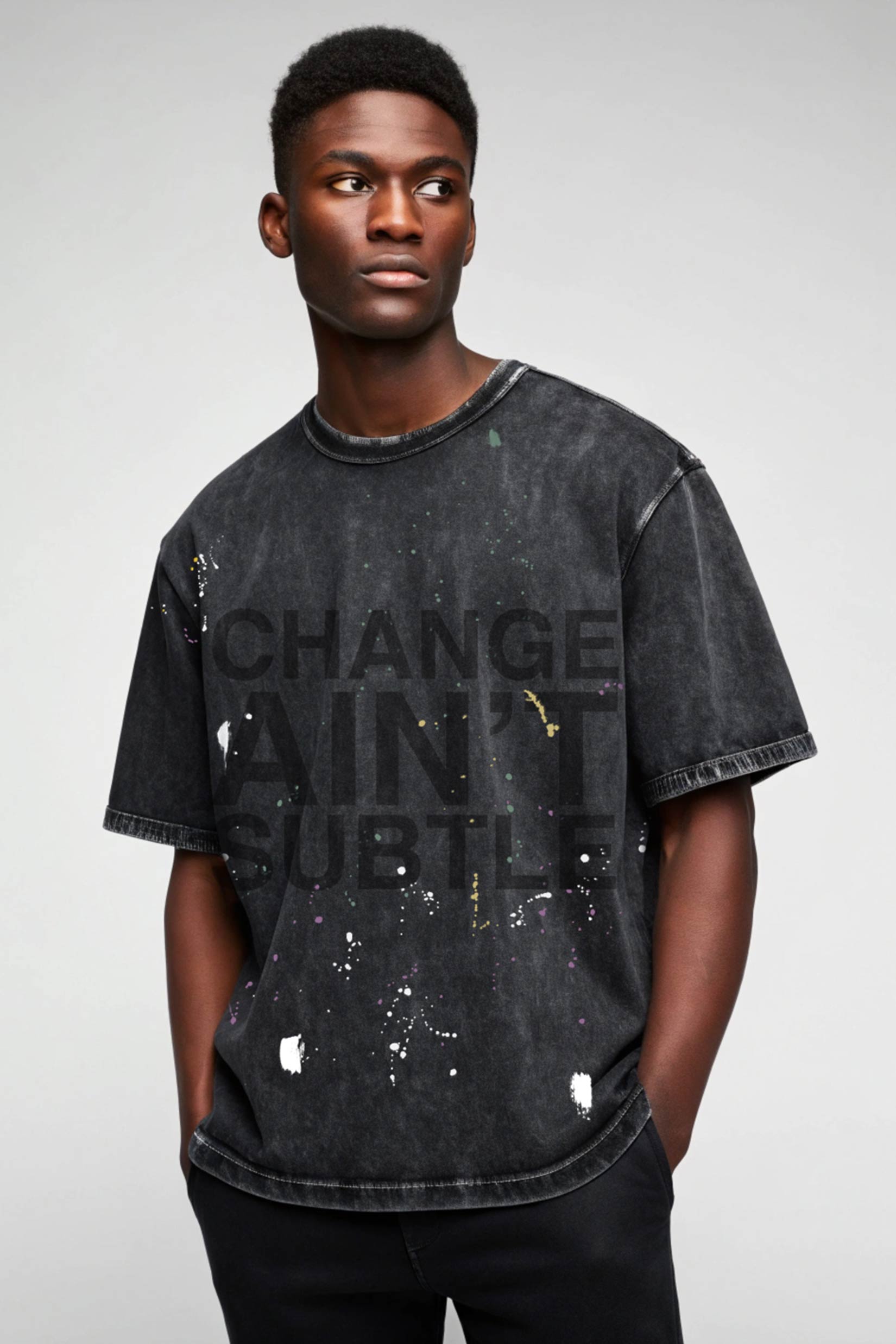 Stylera washed black oversized men's trendy graphic tee with bold text print and paint splatter detail on model