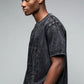 Stylera men's trendy graphic tee washed black oversized fit with paint splatter worn by male model side profile