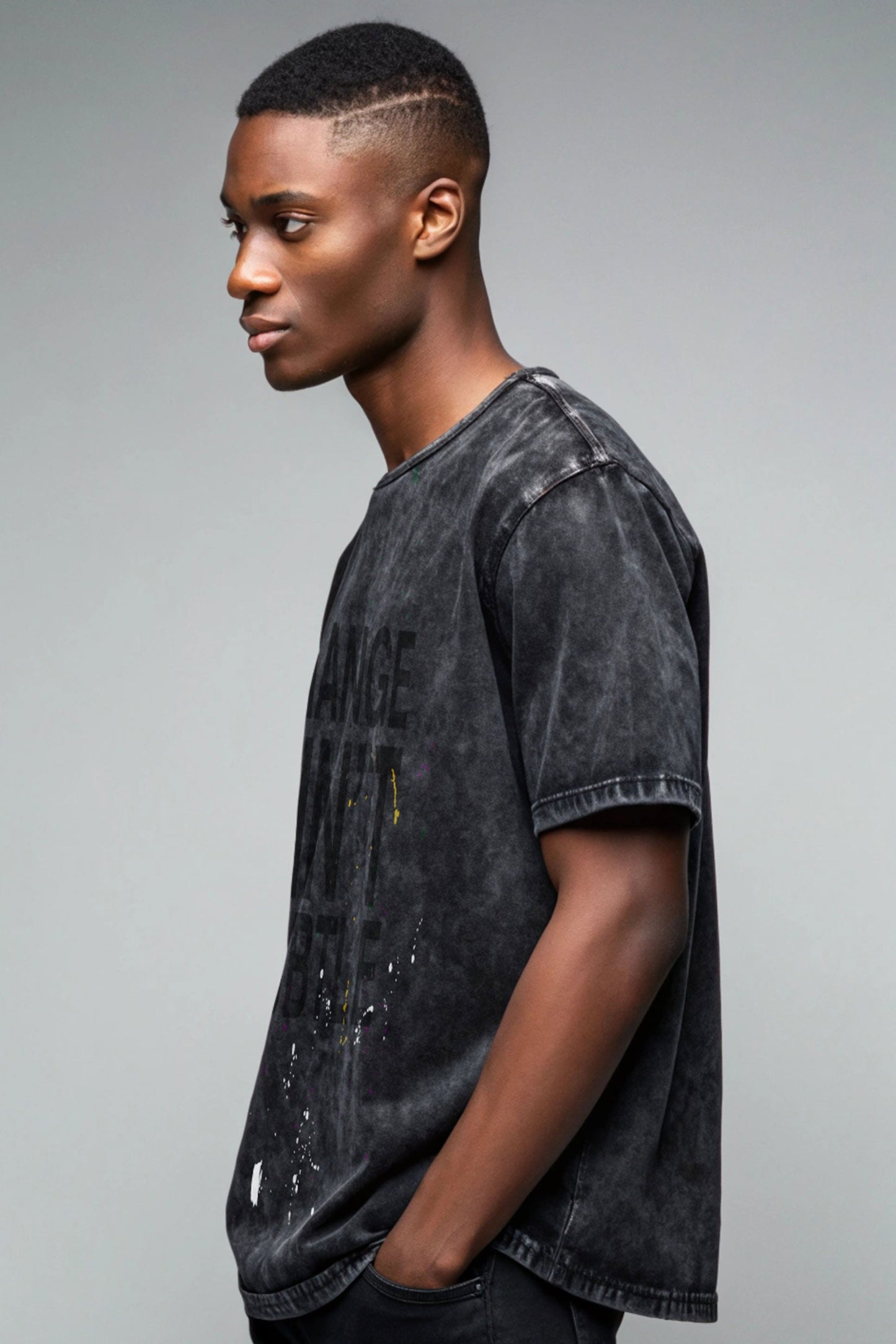 Stylera men's trendy graphic tee washed black oversized fit with paint splatter worn by male model side profile