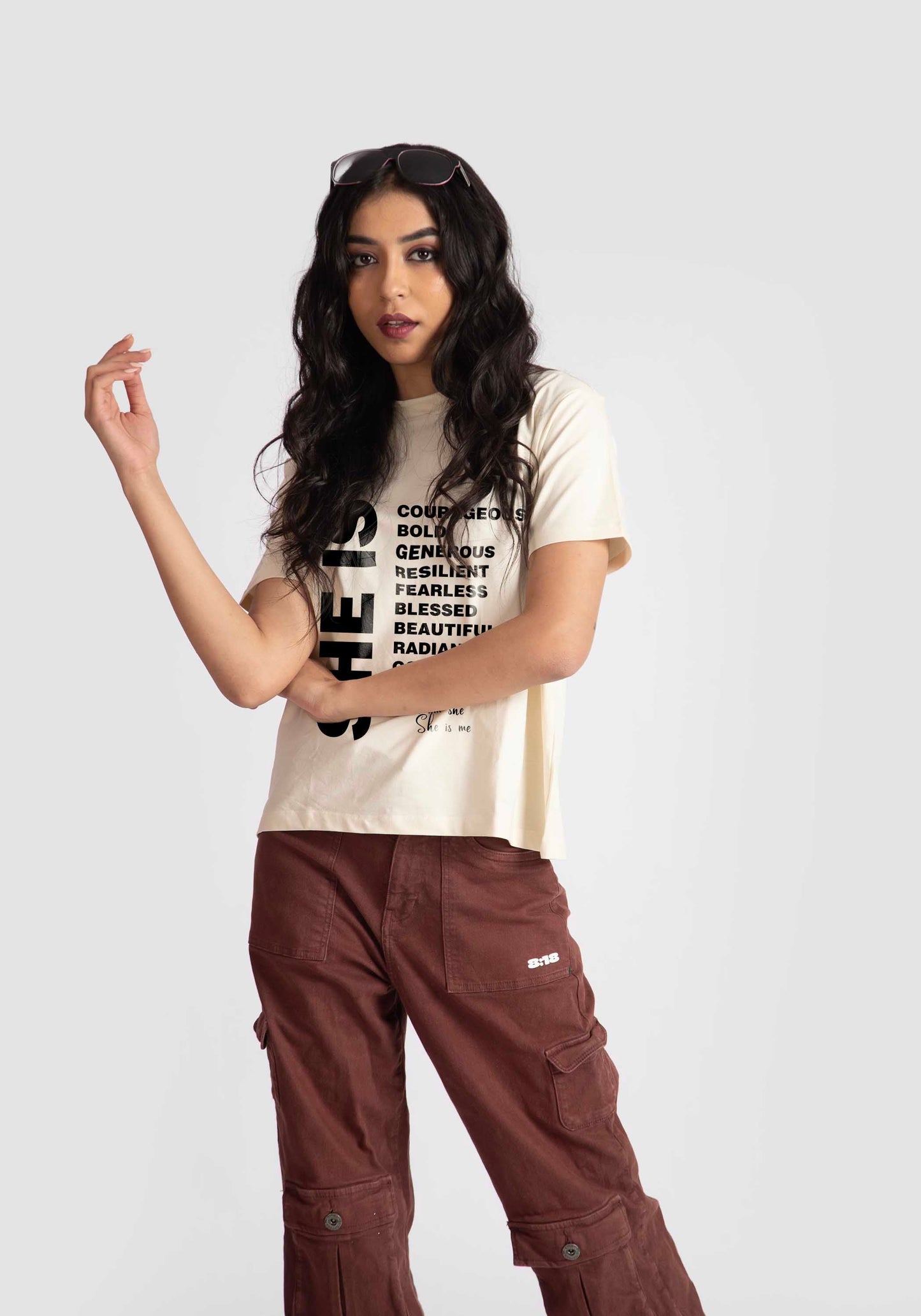 Motivational quote off white t-shirt for women worn by model with curly hair and brown cargo pants