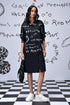 Model wearing Stylera oversized black shirt dress trendy with white script print long sleeves side slit and sneakers