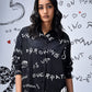 Stylera model wearing oversized black shirt dress trendy with white graffiti print and spread collar