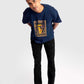 Stylera regular fit art print t-shirt in navy blue worn by male model paired with black pants and white sneakers