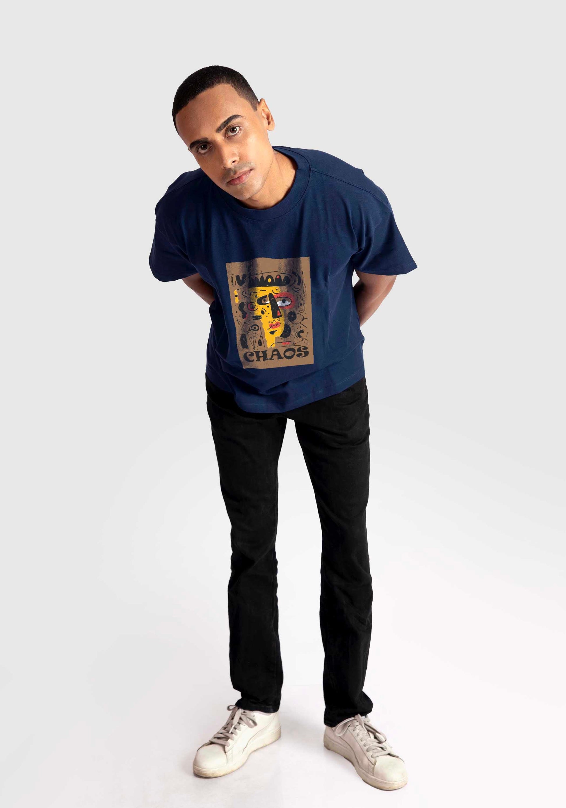 Stylera regular fit art print t-shirt in navy blue worn by male model paired with black pants and white sneakers