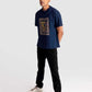 Man wearing a navy regular fit art print t-shirt by Stylera paired with black pants and white sneakers