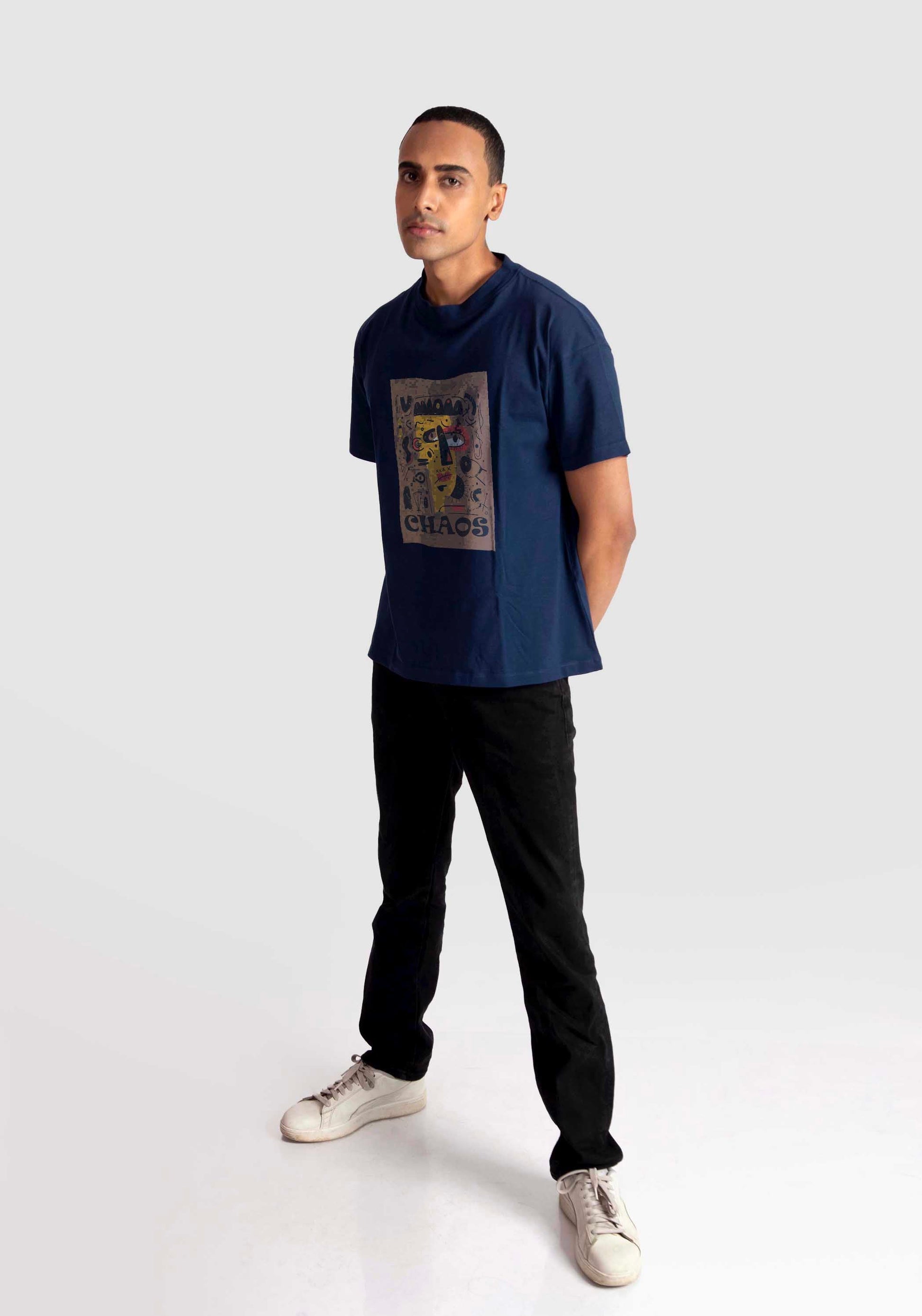 Man wearing a navy regular fit art print t-shirt by Stylera paired with black pants and white sneakers