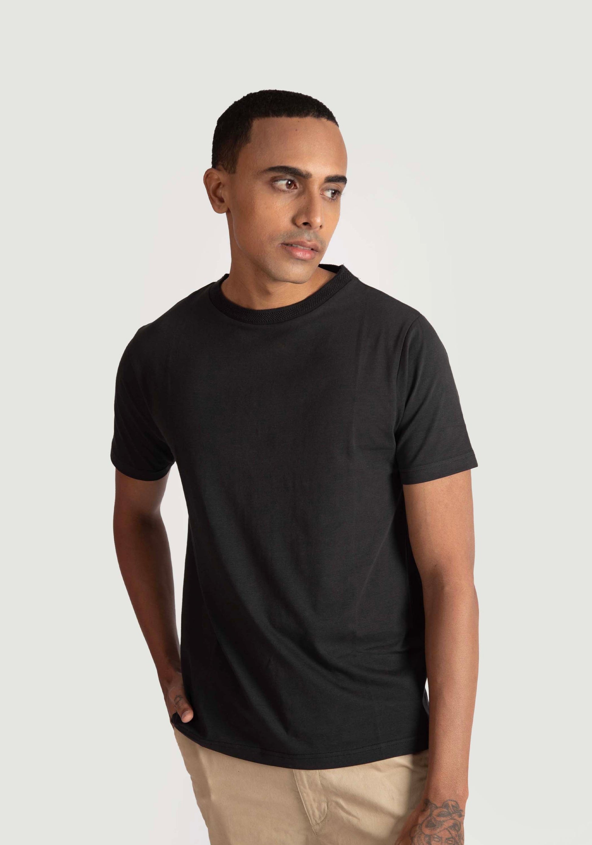 Stylera regular fit black tee for men worn by a male model with short hair and beige pants
