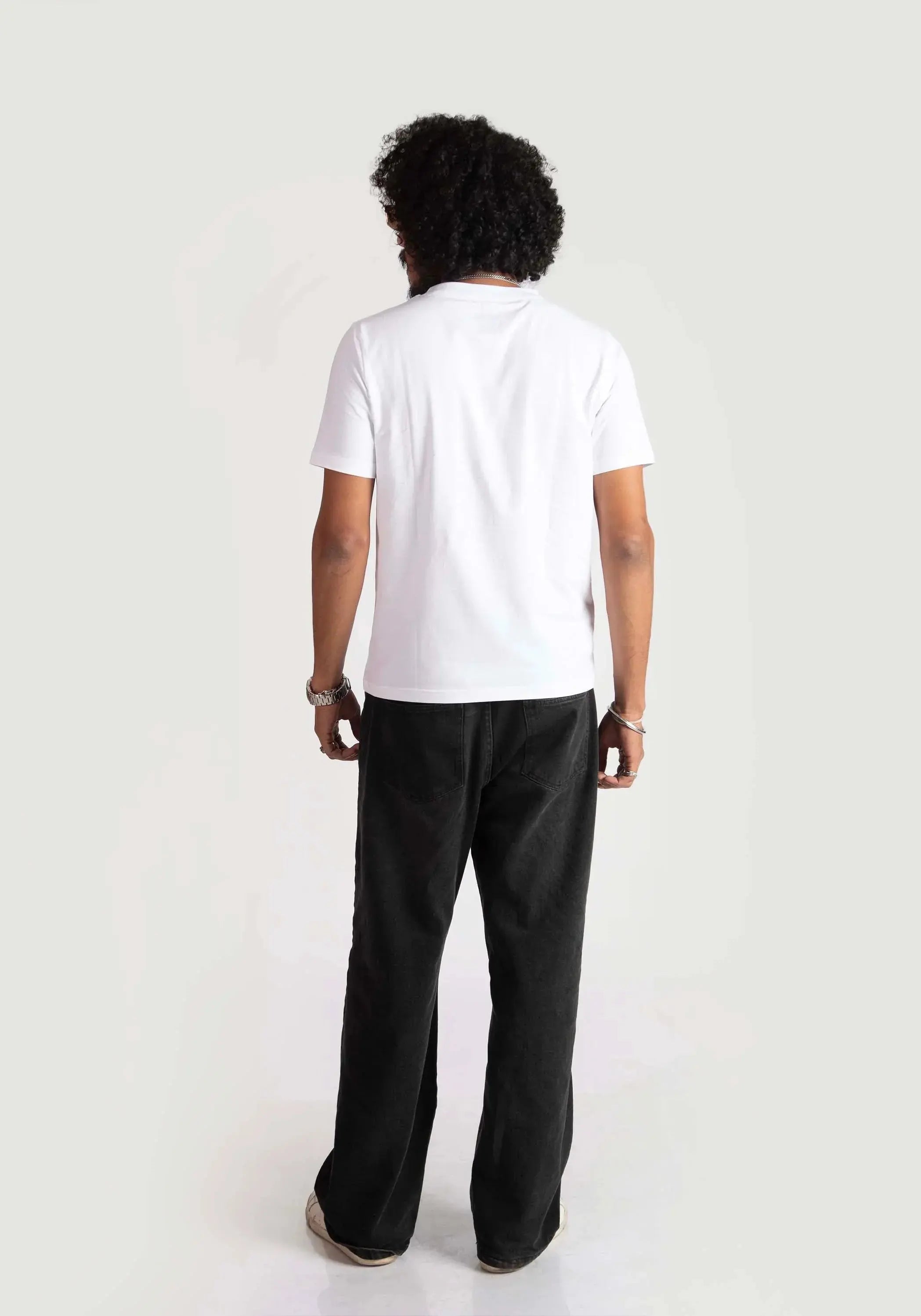 Back view of a man wearing Stylera regular fit white tee paired with black pants