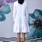 Back view of relaxed fit white dress for women long sleeve tiered shirt dress on model with black boots