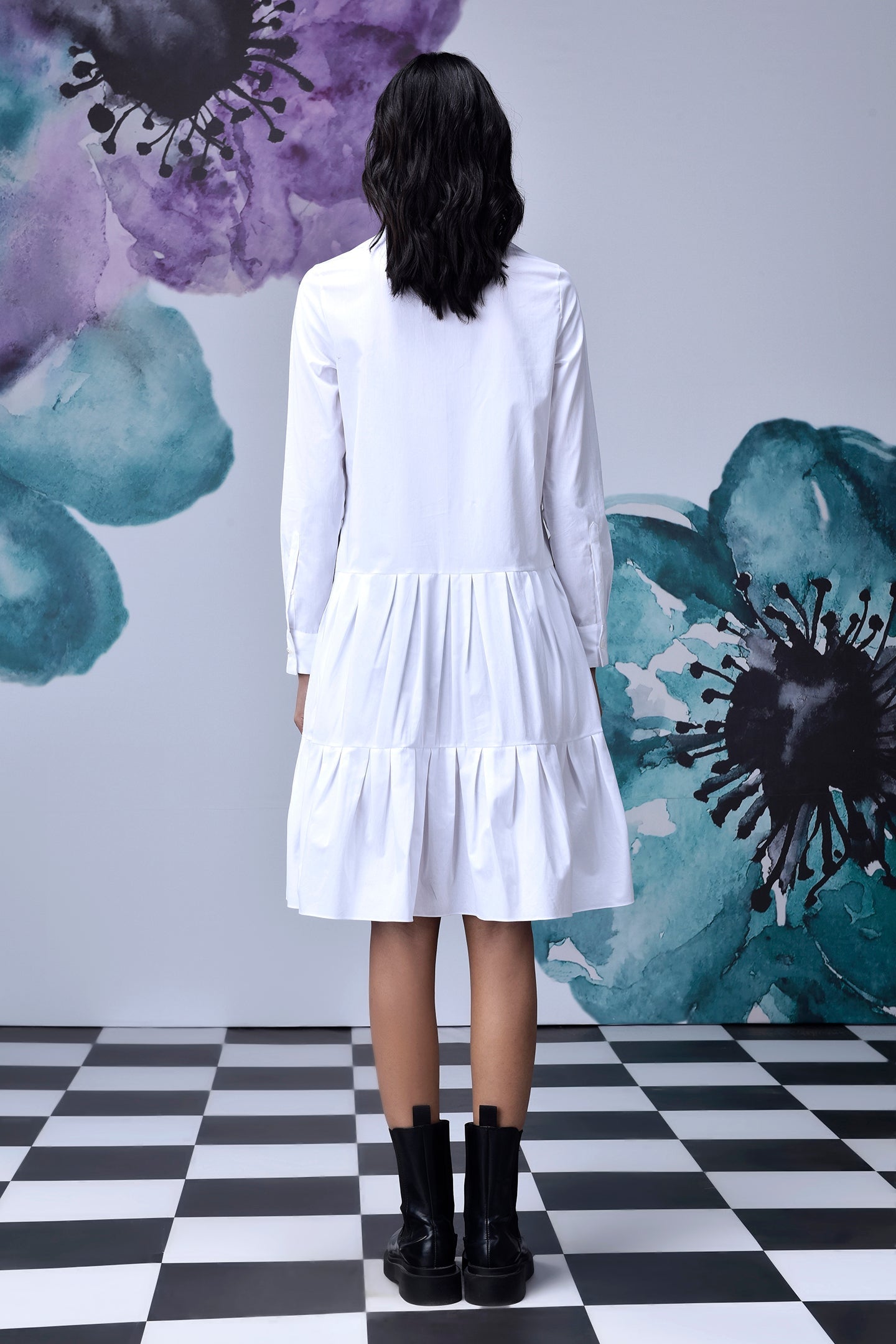Back view of relaxed fit white dress for women long sleeve tiered shirt dress on model with black boots