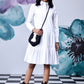 Model wearing relaxed fit white dress for women by Stylera with ruffle collar and tiered skirt
