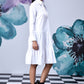 Stylera model wearing relaxed fit white dress for women with tiered skirt and black boots