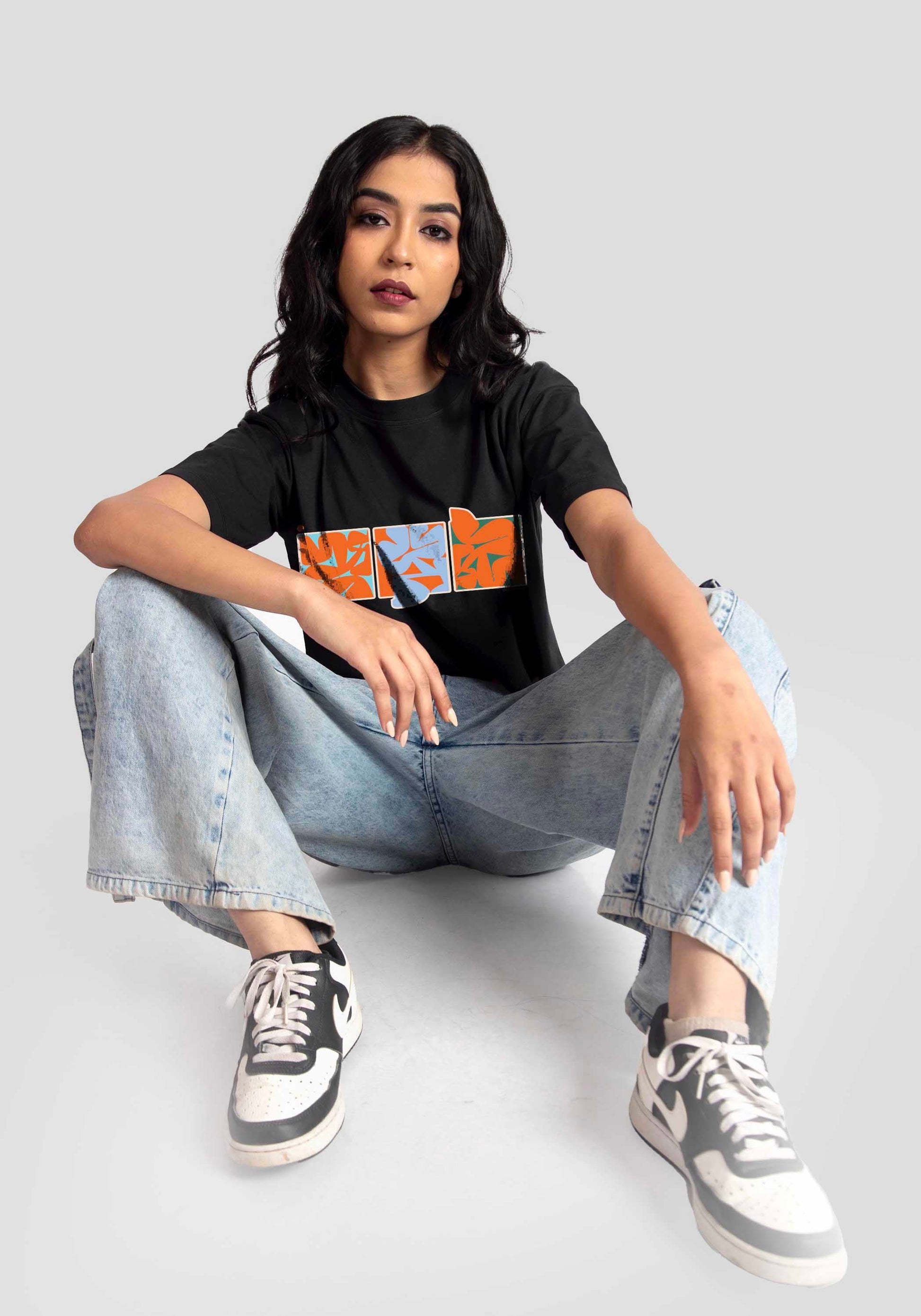 Trendy black oversized crop fit t-shirt by Stylera worn with light blue jeans and sneakers