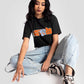 Stylera trendy black oversized crop fit t-shirt worn by model with light blue jeans and sneakers