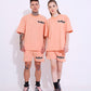 Male and female models wearing Stylera peach matching set with trendy oversized casual t-shirt and shorts