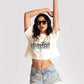 Woman wearing Stylera white oversized crop fit tee with graphic print and denim shorts
