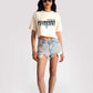 Stylera white oversized crop fit tee with graphic print worn with denim shorts and sneakers