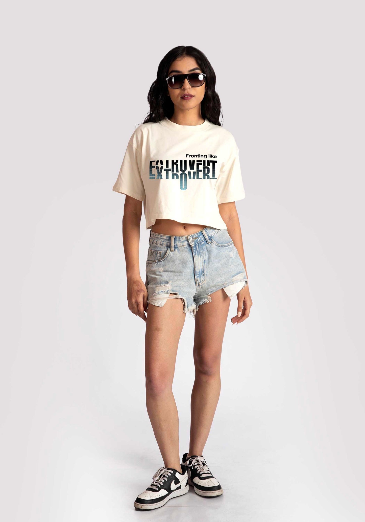 Stylera white oversized crop fit tee with graphic print worn with denim shorts and sneakers