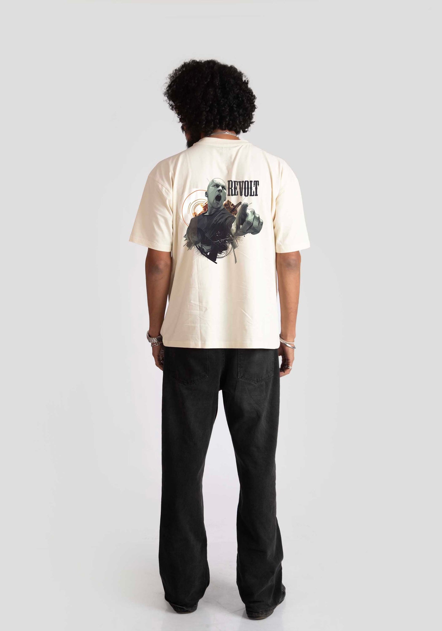 Back view of man wearing white oversized printed t-shirt with graphic design and black pants