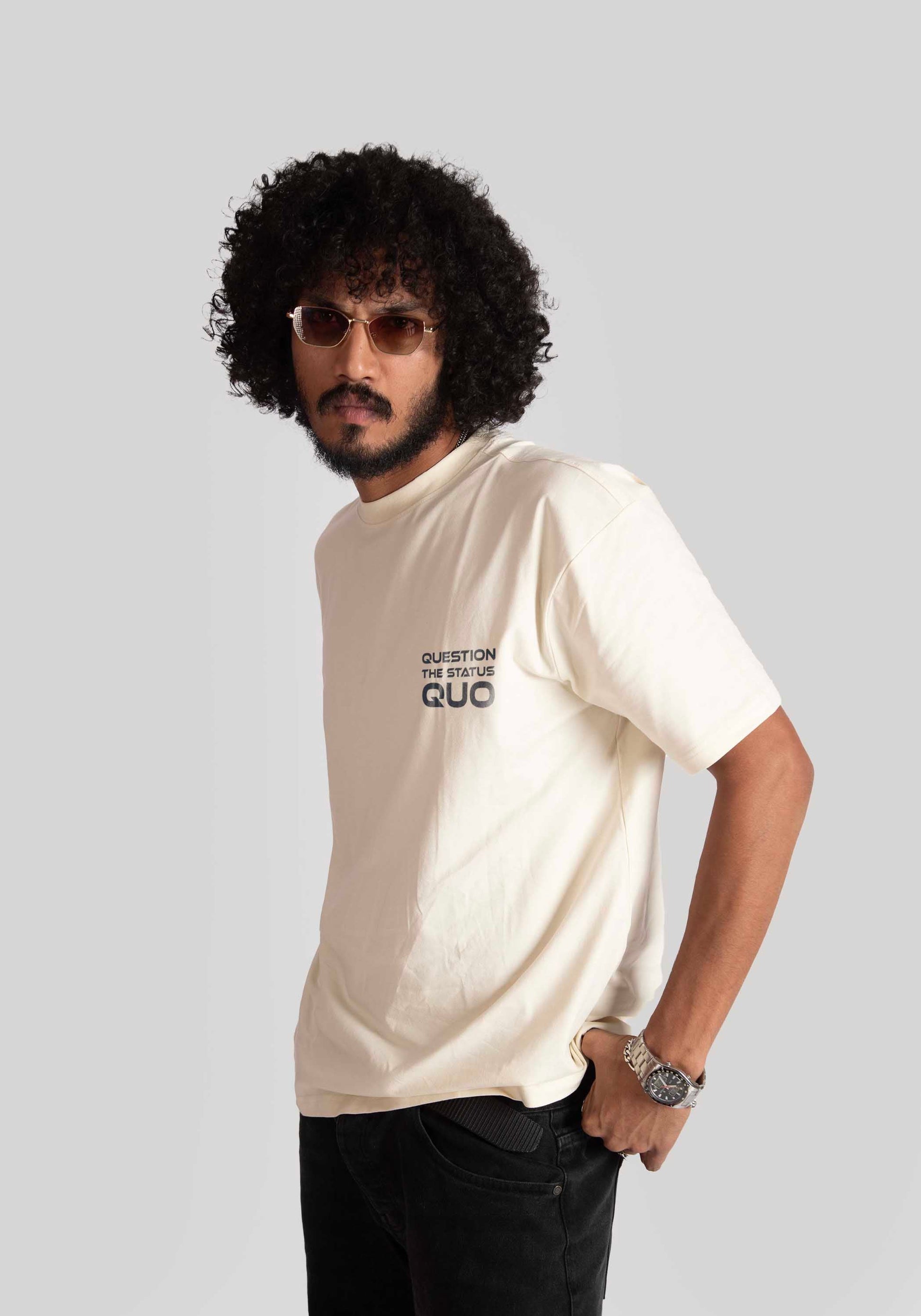 Man wearing Stylera white oversized printed t-shirt with black text and black pants