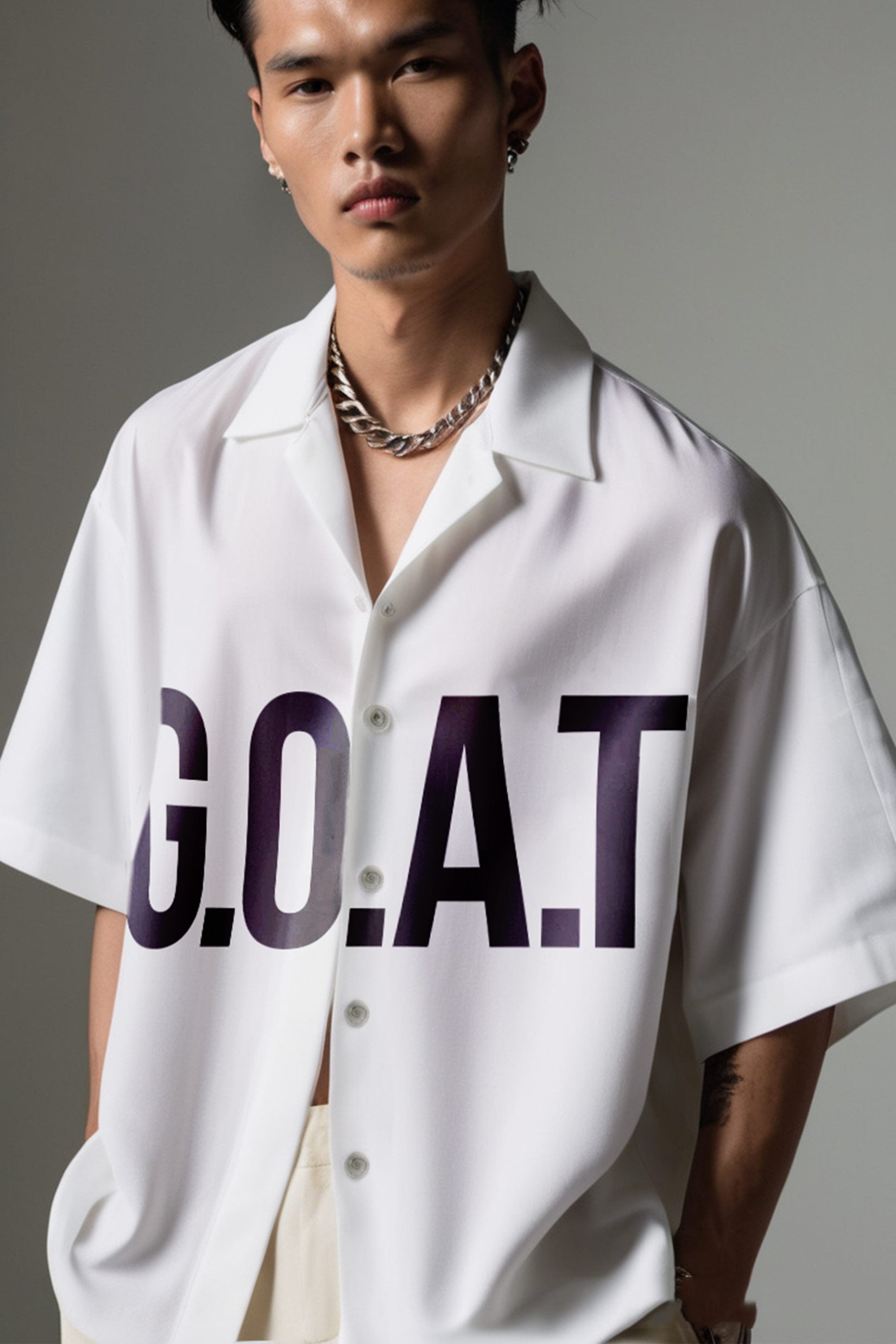 Stylera  model wearing white trendy summer shirt short sleeve with bold GOAT print open collar and chain