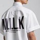 Stylera model wearing white trendy summer shirt with bold MILK back print short sleeves relaxed fit