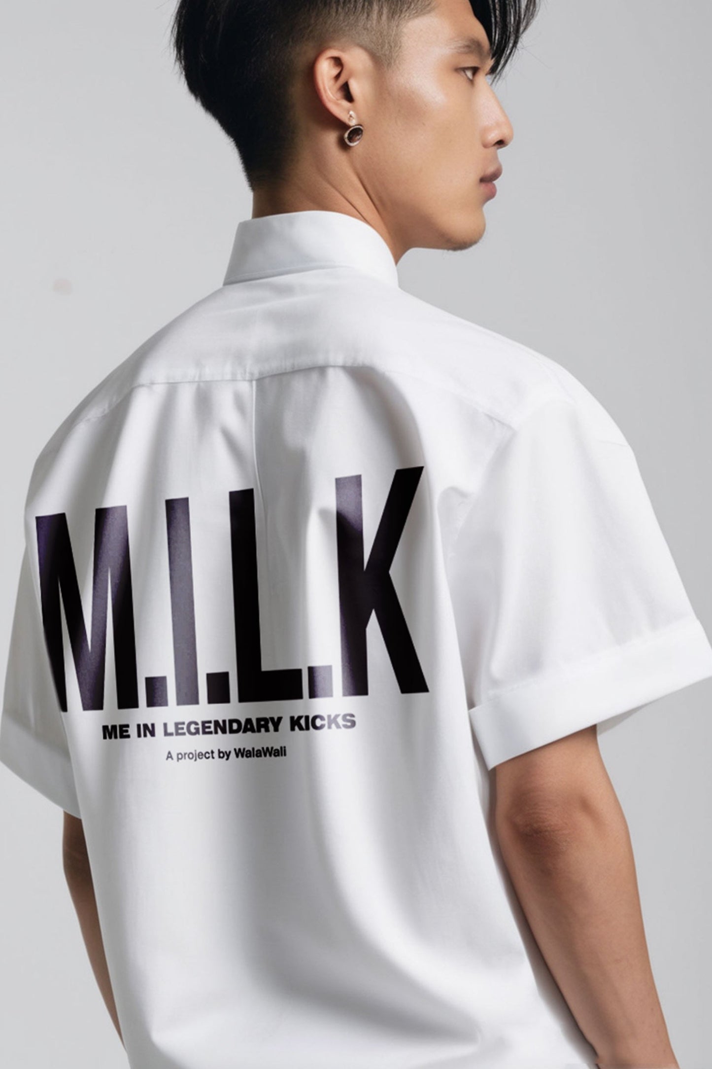 Stylera model wearing white trendy summer shirt with bold MILK back print short sleeves relaxed fit