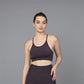 A woman models the Wine Sports Bra, paired with matching leggings, against a plain gray background.